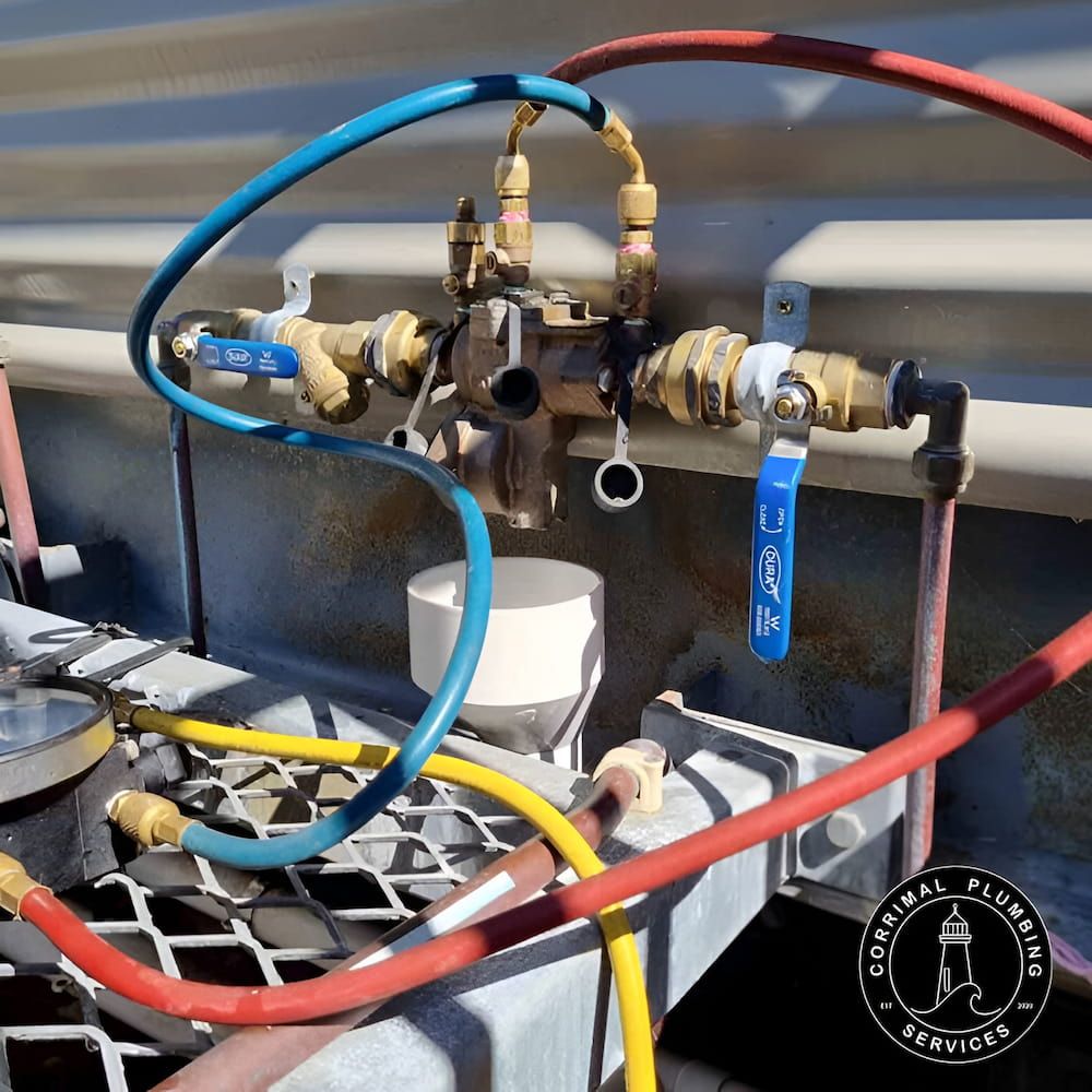 A Complex System of Pipes and Valves, Including Blue, Yellow, and Red Hoses — Corrimal Plumbing Services in Austinmer, NSW