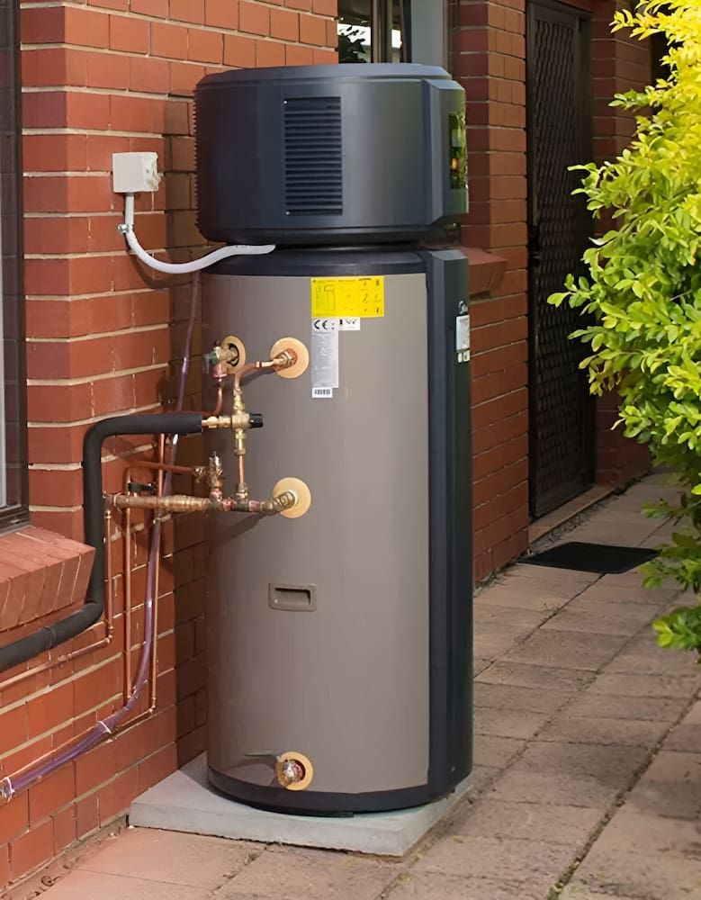 Heat Pump Water Heater Installed Outside on a Brick Wall — Corrimal Plumbing Services in East Corrimal, NSW